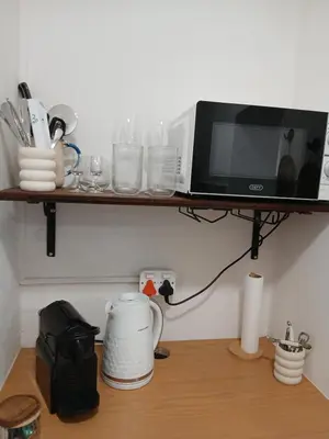a microwave sitting on a shelf above a kitchen counter at Petite Vine in Stellenbosch