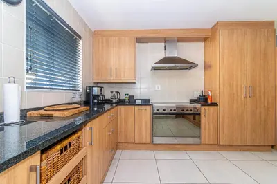 a kitchen with wooden cabinets and a counter top at Four Pines in Hermanus