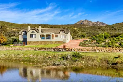 a house on a hill next to a body of water at Blue Crane House