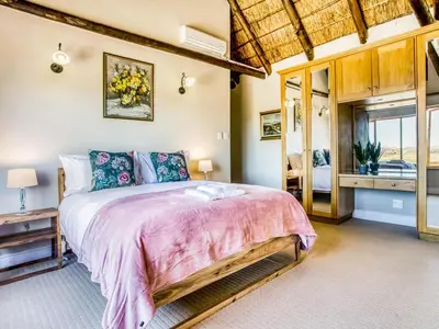 a bedroom with a bed with a pink bedspread at Blue Crane House