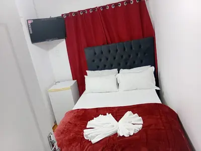 a bedroom with a bed with a red curtain at PEACEFUL SLEEP lodge in Goodwood