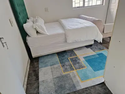 a living room with a couch and a rug at PEACEFUL SLEEP lodge in Goodwood