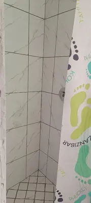 a bathroom with a shower with a white tile wall at PEACEFUL SLEEP lodge in Goodwood