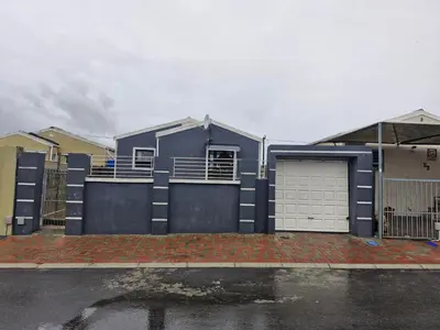 a blue house with a gate and a garage at Kay's Guest Apartments in Kraaifontein