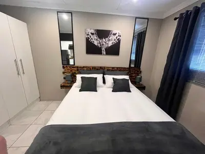 a bedroom with a large white bed with two pillows at Casa Bracken in Windsor Park