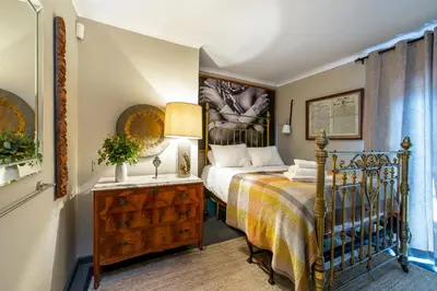 a bedroom with a bed and a table with a lamp at The smallest farm in Africa ELGIN in Grabouw
