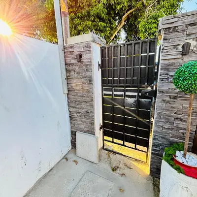 a gate to a backyard with a fence at Browns villa and construction pty ltd in Cape Town