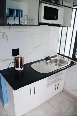 a kitchen counter with a sink and a microwave at Browns villa and construction pty ltd in Cape Town