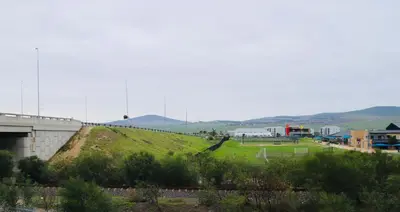 a grassy hill with a building and a field at Browns villa and construction pty ltd in Cape Town