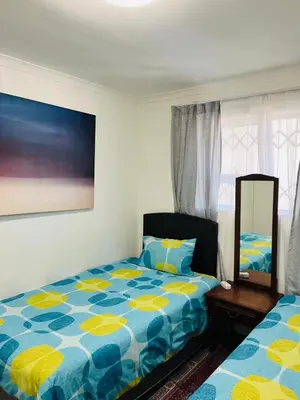 a bedroom with a bed and a mirror at 2 bedroom flat in Pinelands near Old Mutual in Cape Town