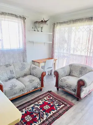 a living room with two couches and a table at 2 bedroom flat in Pinelands near Old Mutual in Cape Town