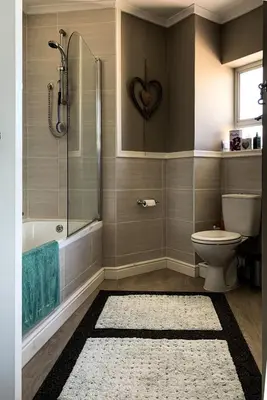 a bathroom with a shower and a toilet and a sink at PENTHOUSE Luxury Apartment Amazing Sea Views CAPE TOWN in Strand