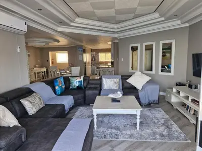 a living room with a couch and a coffee table at PENTHOUSE Luxury Apartment Amazing Sea Views CAPE TOWN in Strand