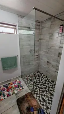 a shower with a glass door in a bathroom at Sunbird Studio Apartment in Brackenfell