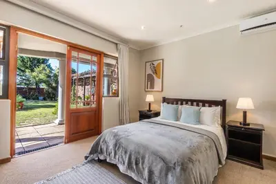 a bedroom with a bed and a sliding glass door at Tambula Guest House in Cape Town