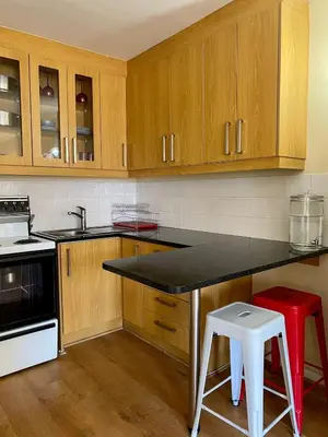 a kitchen with wooden cabinets and a black counter top at Studio Apartment 100 meters to Strand Beach in Strand