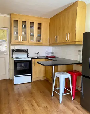 a kitchen with wooden cabinets and a black counter top at Studio Apartment 100 meters to Strand Beach in Strand