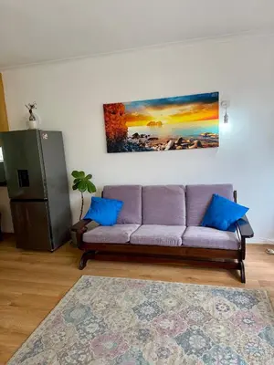 a living room with a couch and a painting on the wall at Studio Apartment 100 meters to Strand Beach in Strand