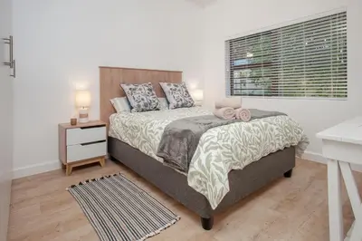 a bedroom with a large bed and a window at Tree Fern Cottage in Hermanus