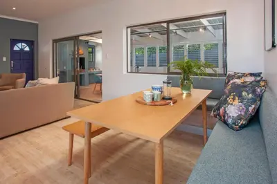 a living room with a table and a couch at Tree Fern Cottage in Hermanus
