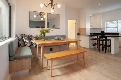 a living room with a table and a couch at Tree Fern Cottage in Hermanus