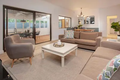 a living room with a couch and a table at Tree Fern Cottage in Hermanus