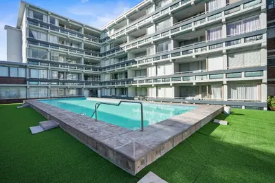 a swimming pool in front of a building at Searenity Tides in Cape Town