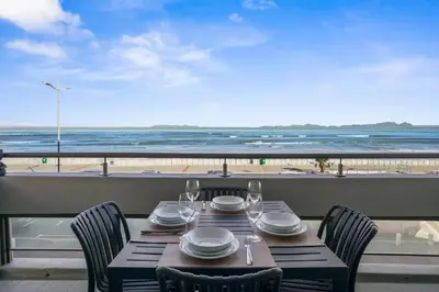 a table with chairs and a view of the beach at Searenity Tides in Cape Town