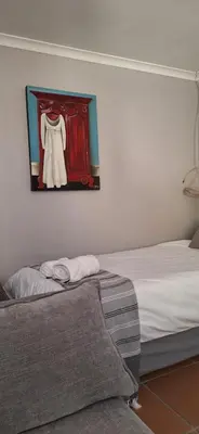 a room with two beds and a painting on the wall at Firehouse selfcatering Garden Cottages no 5 in Wellington