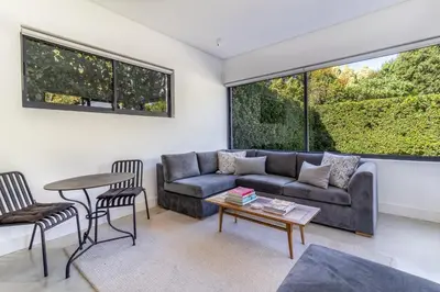 a living room with a couch and a table at Contemporary Apartment With Shared Swimming Pool in Stellenbosch