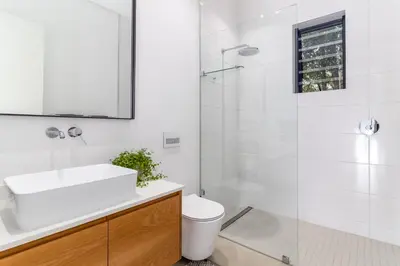 a white bathroom with a sink and a shower at Contemporary Apartment With Shared Swimming Pool in Stellenbosch