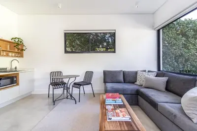 a living room with a couch and a table at Contemporary Apartment With Shared Swimming Pool in Stellenbosch