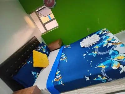 a bed with a blue comforter with butterflies on it at Neo & Ruks Goodwood 1 in Goodwood