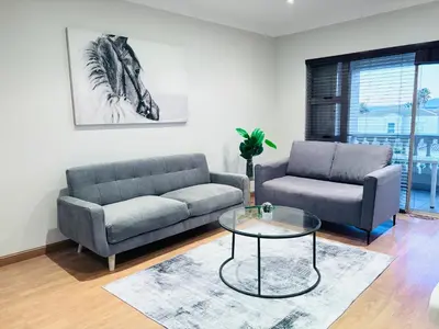 a living room with two couches and a coffee table at Spanish Charm in the Heart of Century City Stylish Stay Near Canal Walk! in Cape Town
