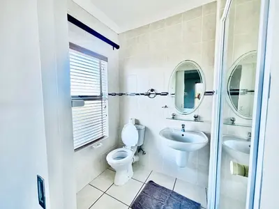 a white bathroom with a toilet and a sink at Spanish Charm in the Heart of Century City Stylish Stay Near Canal Walk! in Cape Town