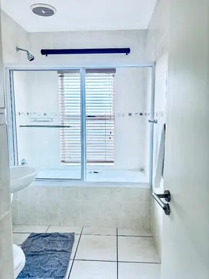 a white bathroom with a tub and a sink at Spanish Charm in the Heart of Century City Stylish Stay Near Canal Walk! in Cape Town