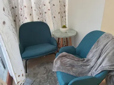 a living room with two chairs and a table at Neats Accommodations in Cape Town