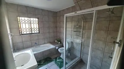 a bathroom with a shower and a toilet and a sink at Somerset Breeze
