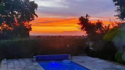 a sunset over a swimming pool with the sun setting at Somerset Breeze