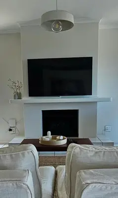 a living room with two couches and a flat screen tv at Tamatiebank in Hermanus