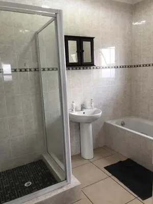 a bathroom with a shower and a sink and a tub at Brackenfell self catering accommodation in Brackenfell
