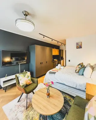 a bedroom with a bed and a table and a couch at Promise on Nine Palms Century in Cape Town