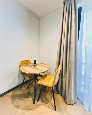a table and two chairs in a room with a window at Promise on Nine Palms Century in Cape Town