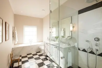 a bathroom with a tub and a toilet and a sink at Leeu House in Franschhoek