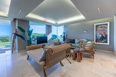 a living room with a couch and chairs at Dolphin View Cabana Beach House in Cape Town