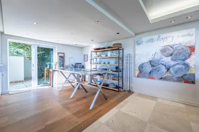 a dining room with a table and a painting on the wall at Dolphin View Cabana Beach House in Cape Town