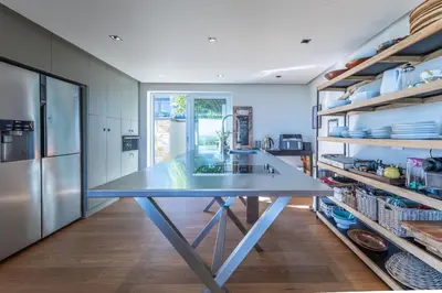 a large kitchen with a large blue table in the middle at Dolphin View Cabana Beach House in Cape Town