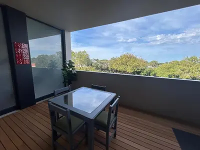 a room with a table and chairs on a balcony at Suite Vos in Hermanus