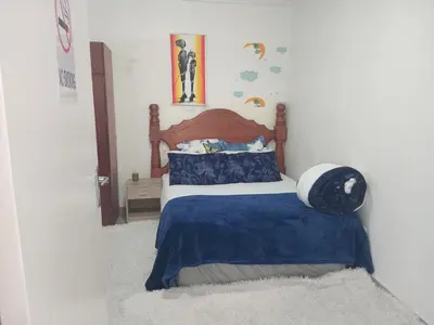 a bedroom with a bed with a blue blanket at Lucian Bed and Breakfast in Goodwood