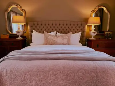 a bedroom with a large bed with two lamps and mirrors at Belle Vallee Guestroom 1 in Wellington